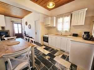 a kitchen with white cabinets and a wooden table at Lemon Nest in Marathokampos