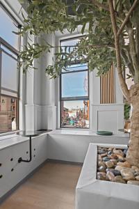 ein Zimmer mit einem Baum und einem großen Fenster in der Unterkunft CityNest New York in New York