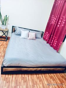 a bed in a room with a red curtain at The Himalayan Homes in Tokna