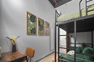ein Zimmer mit einem Etagenbett, einem Tisch und einem Schreibtisch in der Unterkunft CityNest New York in New York