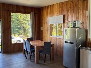a kitchen with a table and a refrigerator at Cabaña de Lujo Independiente in Frutillar
