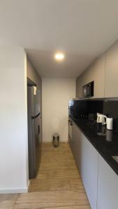 a kitchen with black counter tops and a wooden floor at Sea Side2 in Piriápolis