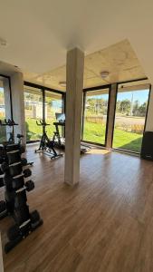 an empty room with a gym with treadmills and windows at Sea Side2 in Piriápolis