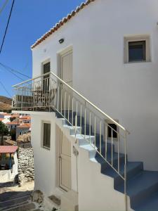 a white house with stairs and a door at Lythi Kythnos in Kithnos