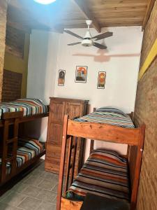 two bunk beds in a room with a ceiling fan at La Nueva Vecindad in San Bernardo