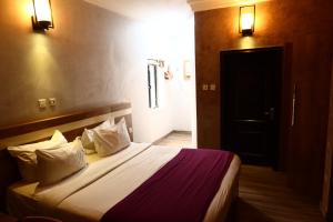 a hotel room with a bed with two pillows at Vienna Suites in Owerri
