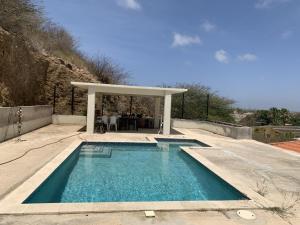 a swimming pool with a gazebo in a yard at Charming house in Curacao in Willemstad