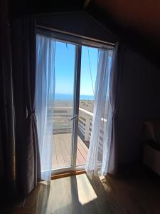 a room with a window with a view of the beach at Casa playa Pullay in Pullay +3 photos