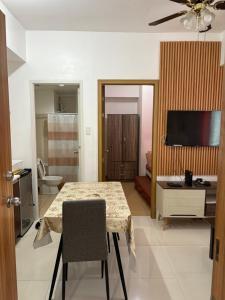 a living room with a table and a bathroom at Urban haven Family&Barkada room in Manila