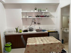 a small kitchen with a table and a sink at Urban haven Family&Barkada room in Manila