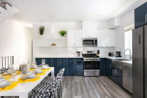 a kitchen with white cabinets and a table with a dining room at Central LA Escape Near Universal & Beaches in Los Angeles