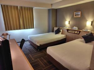 a hotel room with two beds and a window at パーク琴芝 in Ube