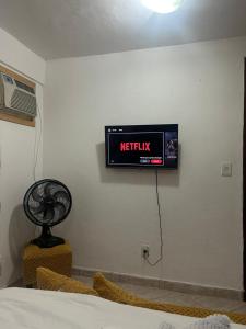 a television on the wall of a room at Recanto da barra in Ilha do Bom Jardim
