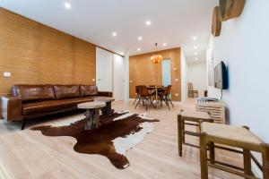 a living room with a leather couch and a table at El Mirador Del Alcazar in Segovia