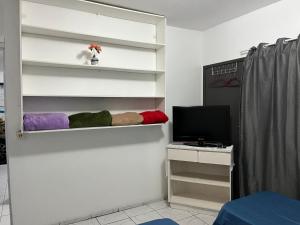 a room with white shelves with a tv and a desk at Espaço Ideal 1 com 2 Quartos in Cascavel