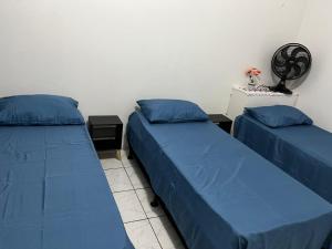 two beds in a room with blue sheets at Espaço Ideal 1 com 2 Quartos in Cascavel