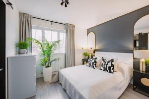 a bedroom with a bed and two potted plants at SleepLuxury ApartHOUSE in Glasgow