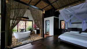 a bedroom with a bed and a bath tub in a room at A Su Homestay Mu Cang Chai in Mù Cang Chải