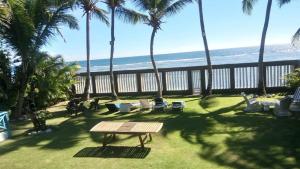 a patio with chairs and a table and the beach at El Mar Azul Franchecis hostal in Juan Dolio