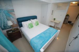 a bedroom with a large bed with a blue headboard at El Mar Azul Franchecis hostal in Juan Dolio