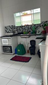 a kitchen with a sink and a microwave at Casa com piscina in Araruama +1 photo