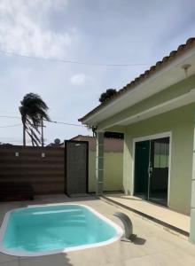 a swimming pool in front of a house at Casa com piscina in Araruama
