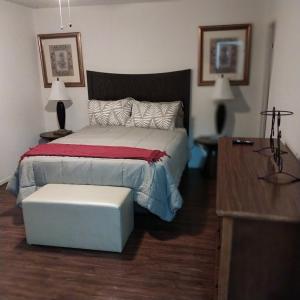 a bedroom with a bed with a bench and a table at The Elect at Pinewood in Millbrook