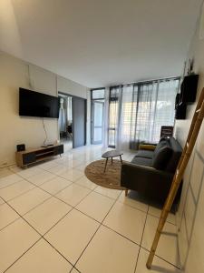 a living room with a couch and a flat screen tv at Appartement 3 chambres récemment rénové in Les Abymes