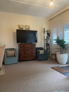 a living room with a large flat screen tv at Katoomba Cosy Cottage - Entire 65sqm Cottage - Queen Bed - Kitchenette - Large Bathroom - Lounge & Sitting Room - Wifi - TV in Katoomba