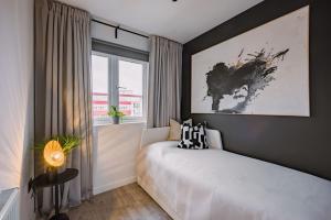 a bedroom with a bed and a large window at ComfySleep ApartHOUSE in Glasgow