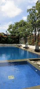 a swimming pool with blue water in a park at Studio Pleasant Tifolia in Jakarta