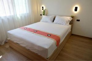a bedroom with a large bed with white sheets at Tree House in Ban Rangeng