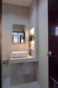 a bathroom with a white sink and a mirror at Tree House in Ban Rangeng