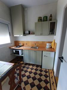 a kitchen with white cabinets and a checkered floor at San Lorenzo I in Chacabuco