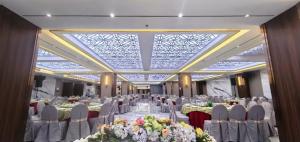 a banquet hall with white chairs and tables with flowers at Lido De Paris Hotel in Manila