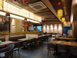 a restaurant with wooden tables and chairs and a bar at Lido De Paris Hotel in Manila
