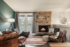 a living room with a fireplace and leather furniture at The Loveland Haus in Loveland