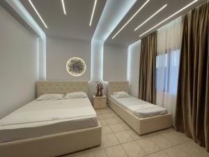 a bedroom with two beds and a window at Hotel Dragoi in Velipojë