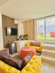 a living room with yellow furniture and a large window at DUBAI by luxury Atitlan in San Pedro La Laguna