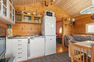 eine Küche mit Kühlschrank und eine Couch in einem Zimmer in der Unterkunft Calm in Nyland