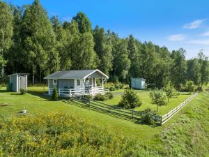 ein kleines Haus auf einem Feld mit einem Zaun in der Unterkunft Calm in Nyland