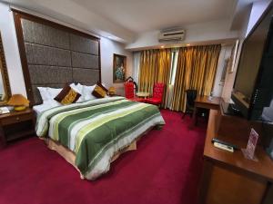 a hotel room with a large bed and a television at Lido De Paris Hotel in Manila +164 photos