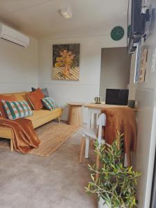 a living room with a couch and a table at Puriri Tiny Home in Orewa