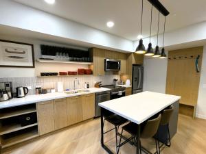 a kitchen with a table and some chairs in it at Black Bears Den, Heated Pool, Hot Tub, AC, brand new unit! in Canmore