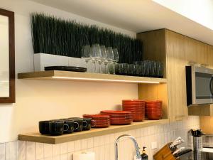 a kitchen with plates and glasses on a shelf at Black Bears Den, Heated Pool, Hot Tub, AC, brand new unit! in Canmore