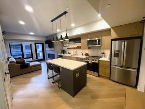 a kitchen with a island in the middle of a room at Black Bears Den, Heated Pool, Hot Tub, AC, brand new unit! in Canmore