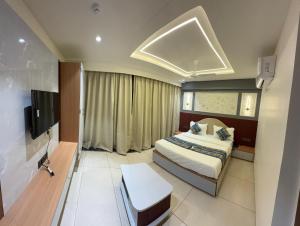 a bedroom with a bed and a flat screen tv at Hotel Vallabh Sky in Goya Gate