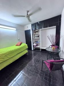 a bedroom with a green bed and a table at Guiñazú in Rodríguez Peña