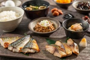 a table with plates of food and bowls of food at Hotel Mystays Premier Hamamatsucho in Tokyo