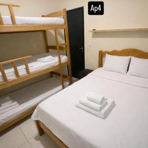 ein Schlafzimmer mit zwei Etagenbetten und weißen Handtüchern in der Unterkunft Residencial Romulo Casa in Manaus